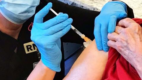 A nurse provides a patient with the COVID-19 vaccine.