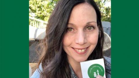 Kelly Measner holding her vaccination sticker