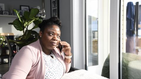 Woman on telephone staring out window.