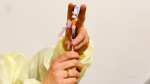 A needle is loaded with flu vaccine.