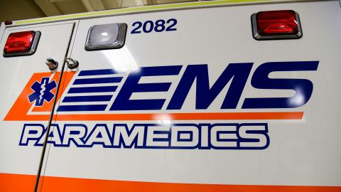 The side of an ambulance with the EMS logo. 