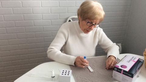 A woman uses a home antigen test kit for COVID-19.