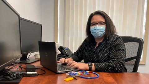 Woman in office in front of a computer.