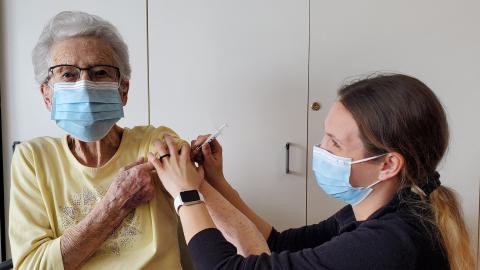 elderly woman receiving her flu vaccine