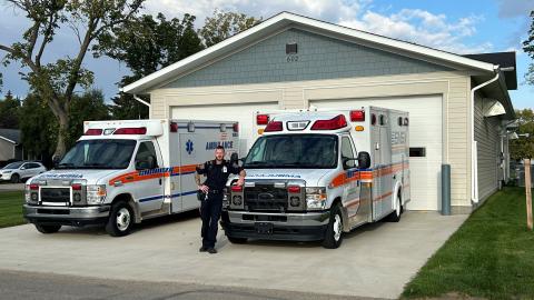 paramedic stands with ambulances outside new bay