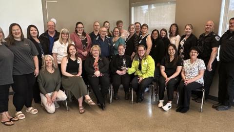 A large group of people representing community groups, businesses and Saskatchewan Health Authority staff in Melfort are pictured together holding an award.