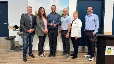 A group of people posing for a photo with the SHA Emerging Innovation award.