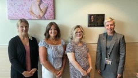 SHA staff standing in front of art at the Regina Breast Health Centre