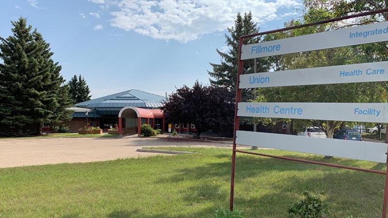 A sign reads Fillmore Health Centre on the right, with the Fillmore Health Centre in the distance on the left.