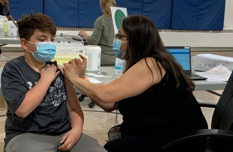 A teenager receives a COVID-19 vaccine.