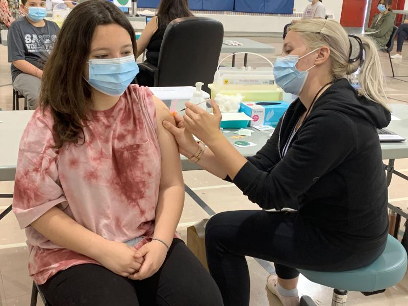 A teenager receives a vaccine