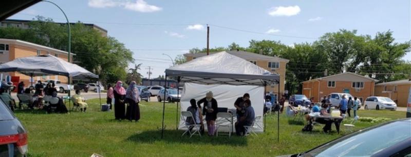 People gather outside their apartment complex to get immunized.