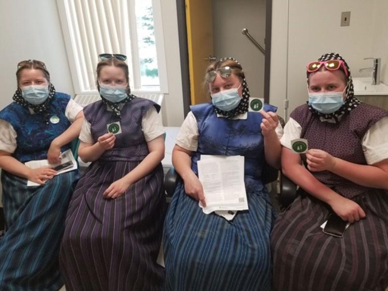 Members of one of Saskatchewan’s Hutterite colonies proudly show their vaccine stickers after receiving a COVID-19 vaccine.