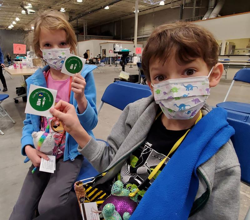 Kids show off their COVID-19 vaccination stickers