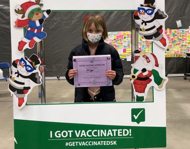 Saige, age 9, holding her COVID-19 Vaccine Superstar certificate in Regina.