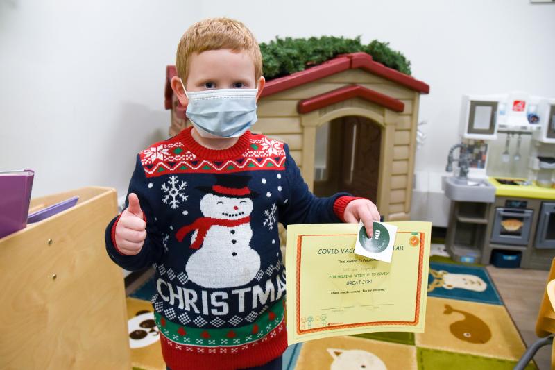 Young William receives his certificate and sticker after getting the COVID-19 vaccine. 