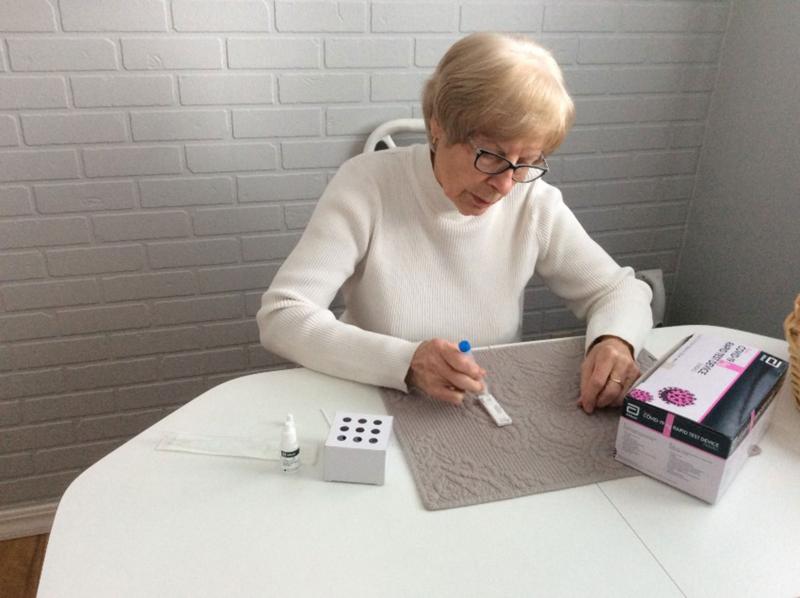 A woman uses a home antigen test kit for COVID-19.