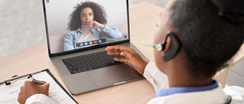 A health-care provider meets virtually with a patient.