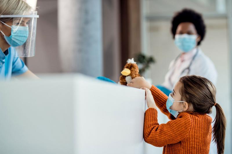 A little girl visits with a triage nurse.