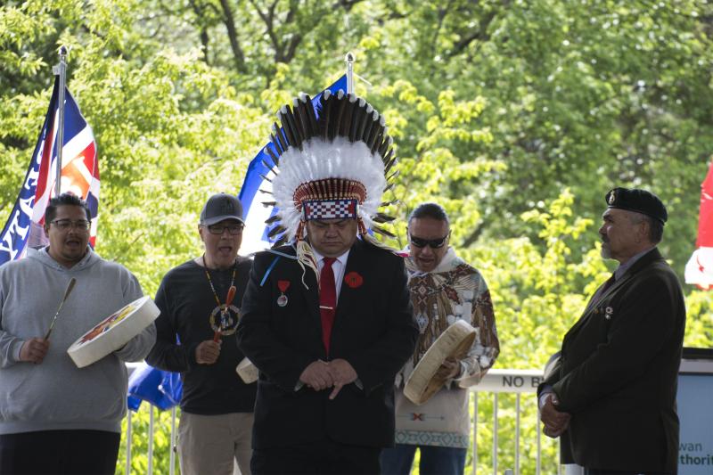 Grand Chief Dave Gamble, along with First Nations and Métis veterans, and the Black Wolf Singers (Iowerate Naytowhow, Darrell Paskemin, Ambrose Metsikassus) prepare to march to raise the Truth and Reconciliation Flag.