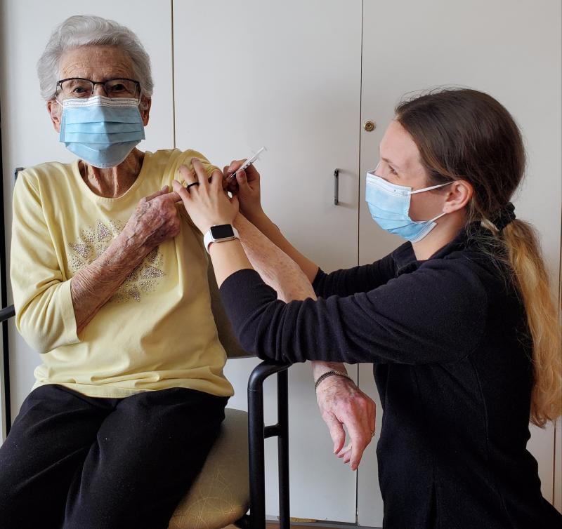 elderly woman receiving her flu vaccine