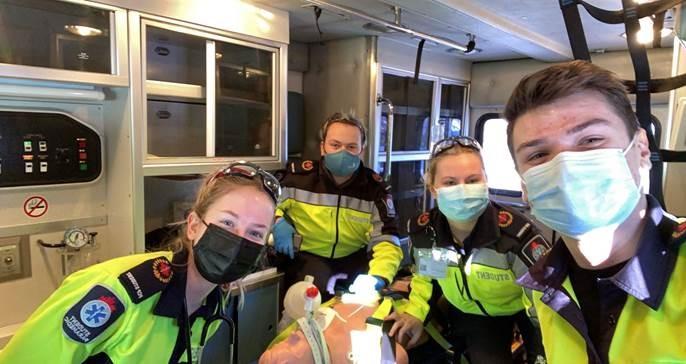Denys Kotelnikov, a Primary Care Paramedic, in the back of an ambulance with three of his team members.