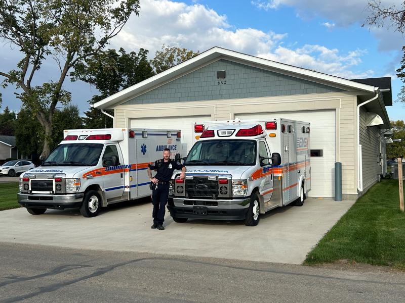 paramedic stands with ambulances outside new bay