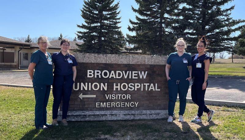 Four members of the nursing team in Broadview, standing beside the Broadview Union Hospital Visitor Emergency sign.