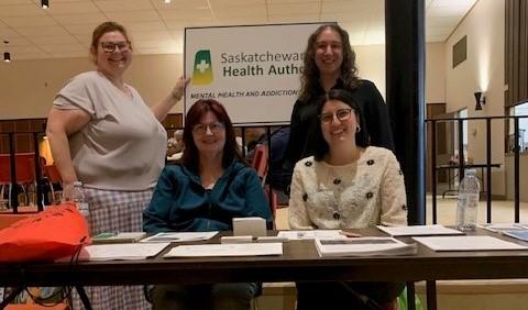 People sitting at a booth at the Kamsack wellness event