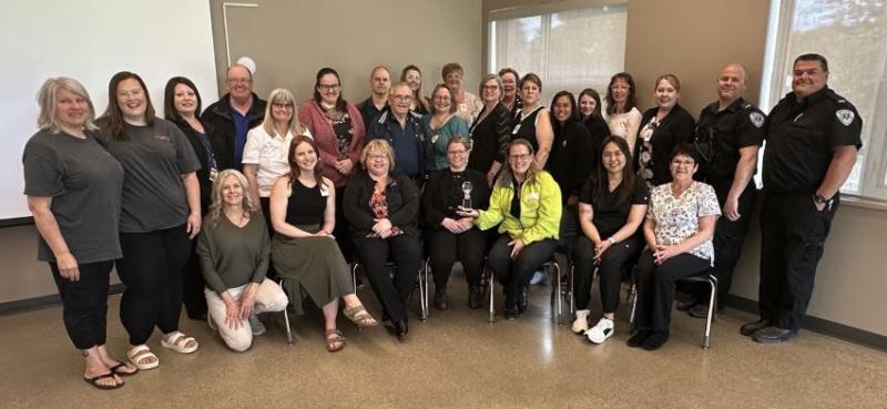 A large group of people representing community groups, businesses and Saskatchewan Health Authority staff in Melfort are pictured together holding an award.