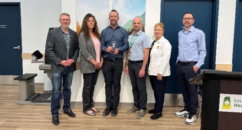 A group of people posing for a photo with the SHA Emerging Innovation award.