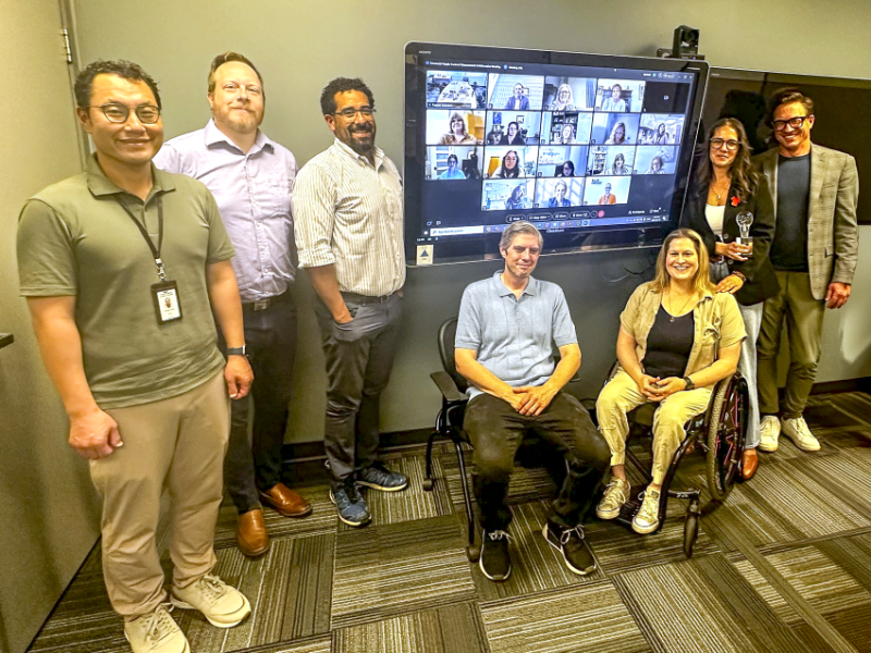 people standing around a screen with an award